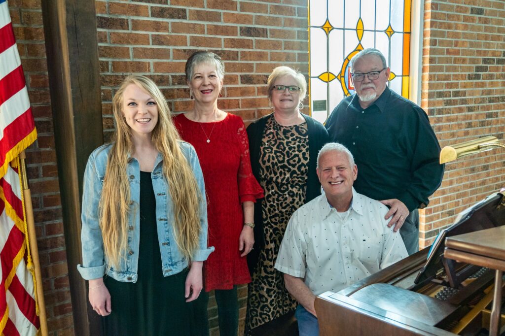 Members of the Riverside Praise Team posing beside the piano